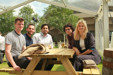 students sat at a table with drinks and picnic